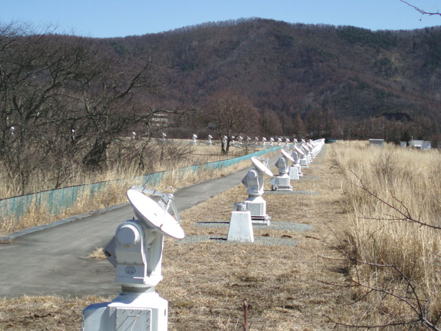 国立天文台野辺山電波観測所電波へリオグラフ　　このたくさんの弧を描いたパラボラアンテナ群は
																				 電波によって太陽を見るもので、アンテナおのおのの受けた電波から太陽の画像を合成する。
																				 これにより太陽周縁のコロナ中の現象を高い空間・時間分解能で観測することができる。