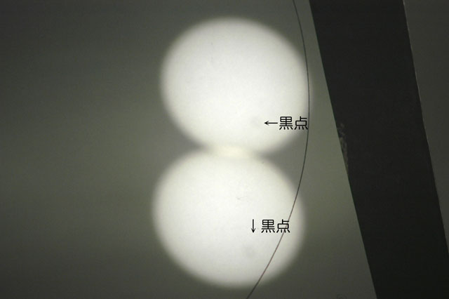 これは大きな黒点が太陽上にあるときに、ピンホール（木もれ日）を通して白紙に写したものだ。
																		  矢印の先にうっすらと暗い箇所があるがこれが黒点である。